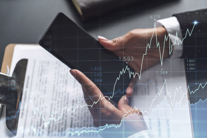 A woman financial trader in formal wear is checking the phone to sign the contract to invest money in stock market. Internet trading and wealth management concept. Forex hologram chart.